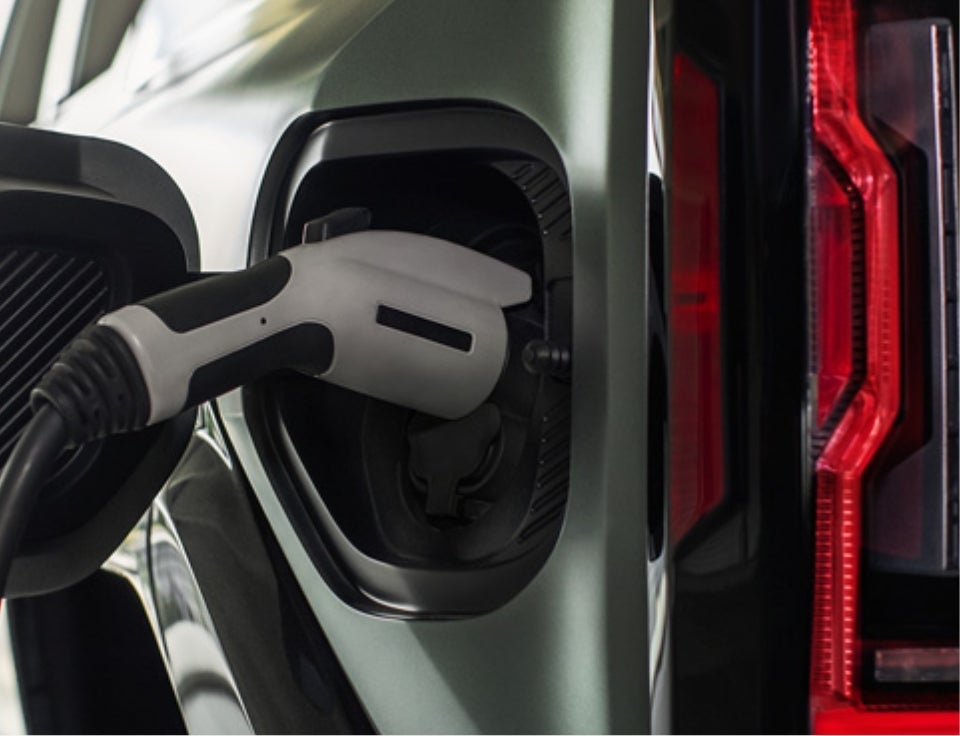 Close up of charging port with charger plugged in on a GMC Hummer EV SUV - Walker Motor Company LLC in KITTANNING PA